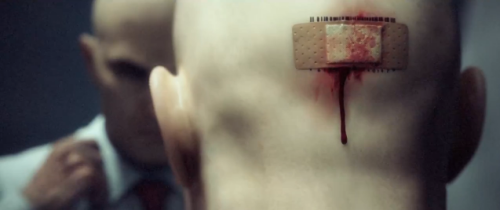The back of 47's head - the barcode is covered with a bloody - as in bleeding - plaster
